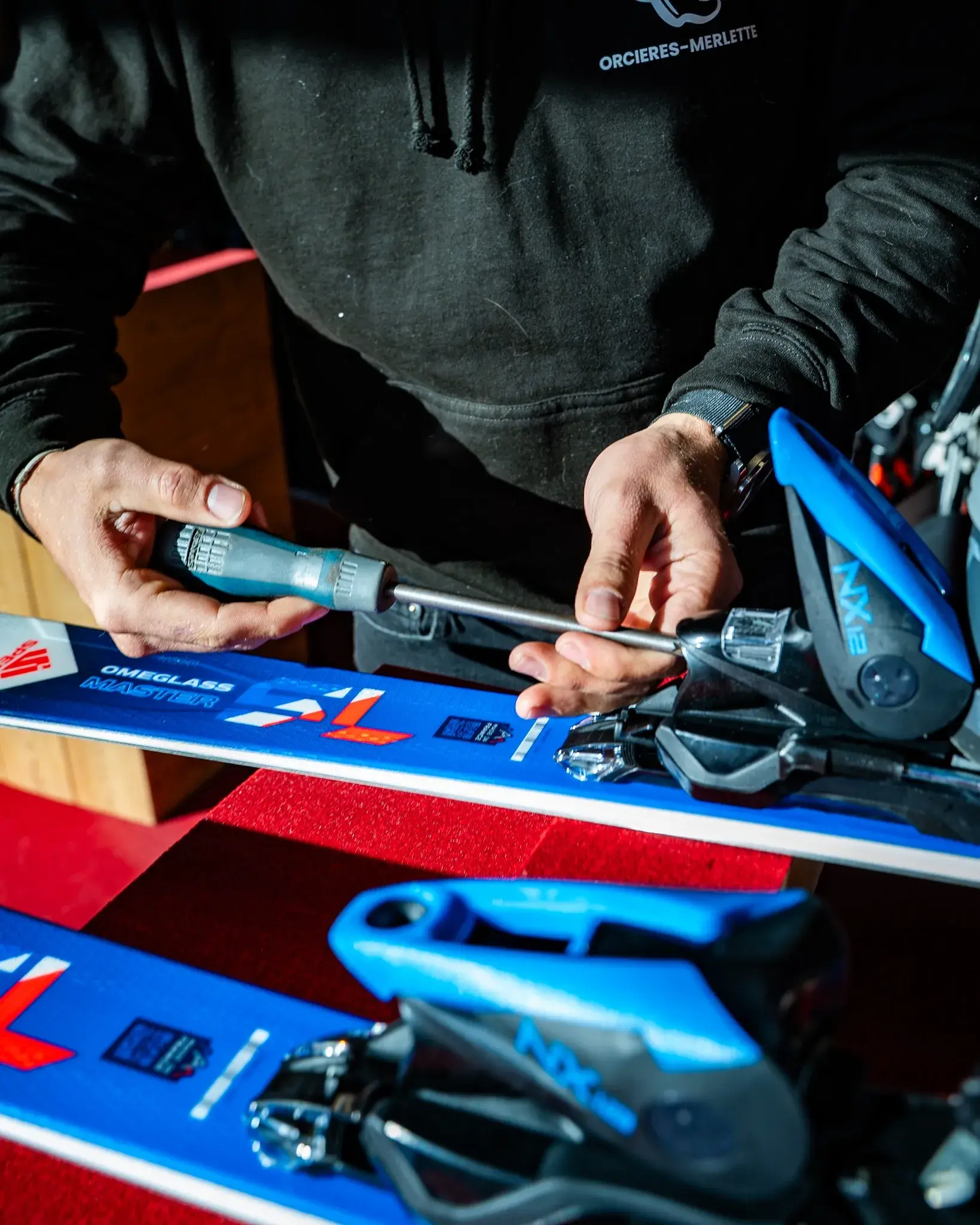 Réglage d’une fixation de ski au tournevis à l’atelier Papy Ski